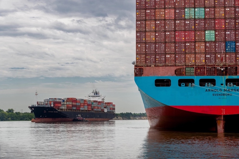 Container ship arriving at port, representing global distribution